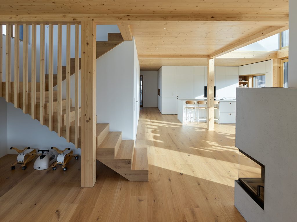 Holzstiegenhaus mit Blick in Küche